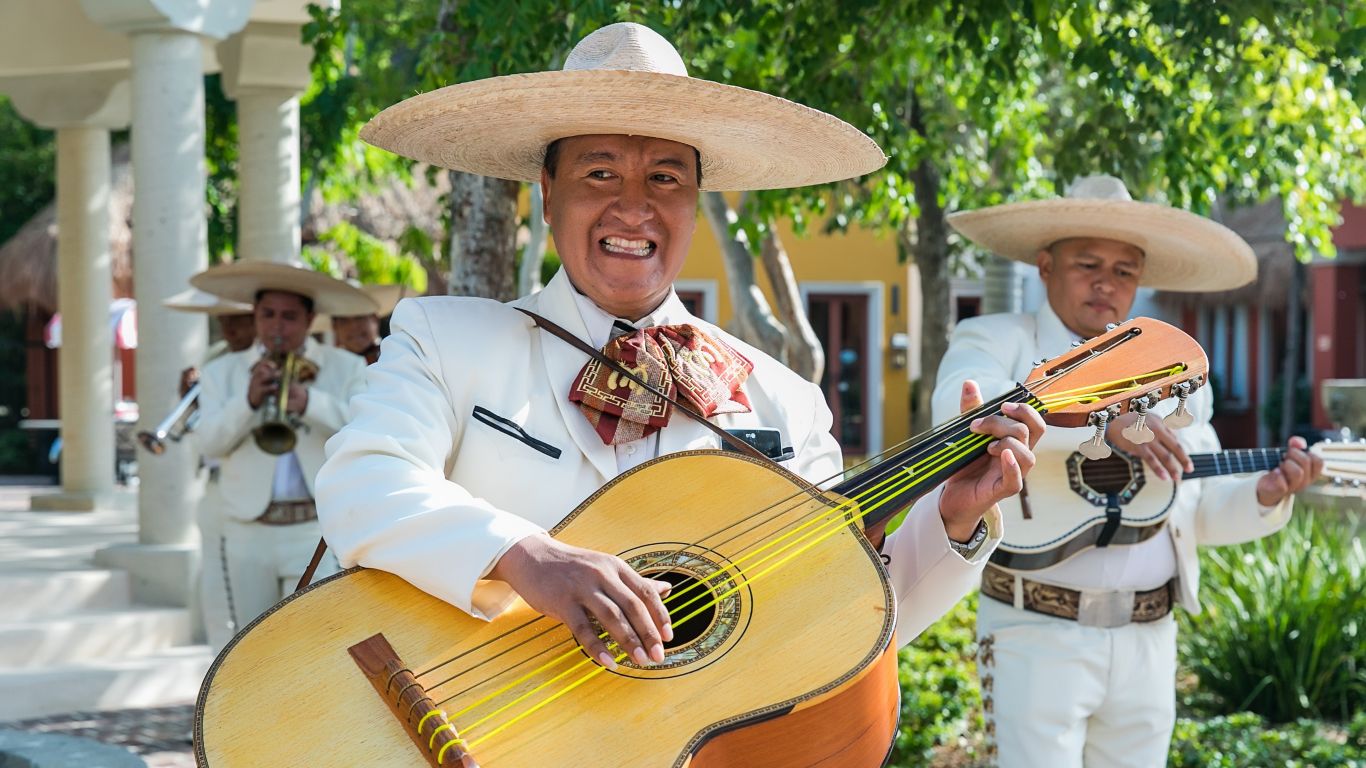 smiling mariachi musicial playing guitar 
